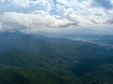 Yazın Ukrayna Karpatları 'nın yeşil dağları. Güneşli bir gün, nadir bulutlar. Hava aracı görünümü.