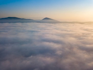 Ukrayna Karpatları 'nda yaz aylarında sislerin üzerinden uçarlar. Ufuktaki dağlar. Hava aracı görünümü.