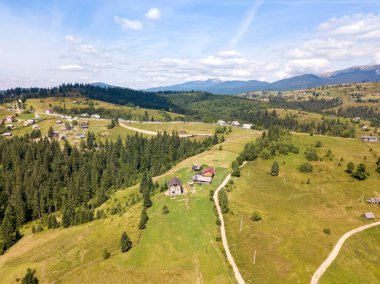Yazın Ukrayna Karpatları 'nın yeşil dağları. Güneşli bir gün, nadir bulutlar. Hava aracı görünümü.