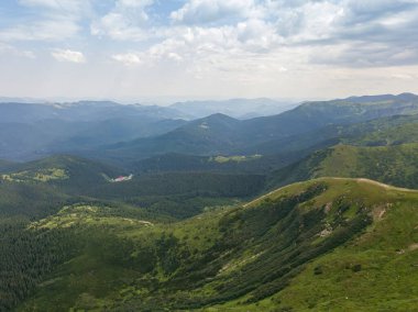 Bulutlu havada Ukrayna Karpatlarının yüksek dağları. Hava aracı görünümü.