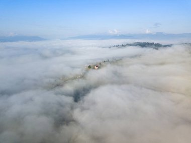 Dağlardaki bulutların üstünde yüksek bir uçuş. Hava aracı görünümü.