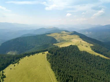 Yazın Ukrayna Karpatları 'nın yeşil dağları. Güneşli bir gün, nadir bulutlar. Hava aracı görünümü.