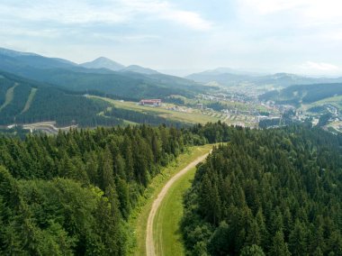 Yazın Ukrayna Karpatları 'nın yeşil dağları. Güneşli bir gün, nadir bulutlar. Hava aracı görünümü.