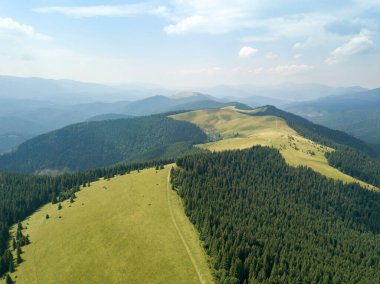 Yazın Ukrayna Karpatları 'nın yeşil dağları. Güneşli bir gün, nadir bulutlar. Hava aracı görünümü.