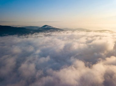Ukrayna Karpatları 'nda yaz aylarında sislerin üzerinden uçarlar. Ufuktaki dağlar. Hava aracı görünümü.