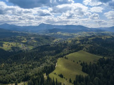 Yazın Ukrayna Karpatları 'nın yeşil dağları. Yamaçlarda kozalaklı ağaçlar. Hava aracı görünümü.