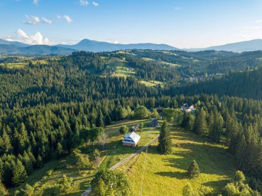 Yazın Ukrayna Karpatları 'nın yeşil dağları. Güneşli bir gün, nadir bulutlar. Hava aracı görünümü.