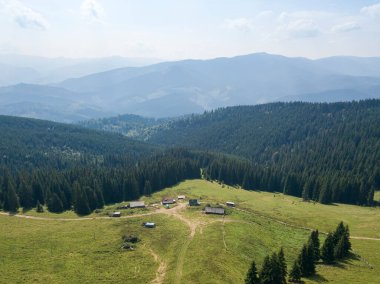 Yazın Ukrayna Karpatları 'nın yeşil dağları. Güneşli bir gün, nadir bulutlar. Hava aracı görünümü.