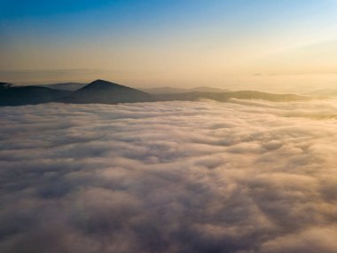 Ukrayna Karpatları 'nda yaz aylarında sislerin üzerinden uçarlar. Ufuktaki dağlar. Hava aracı görünümü.