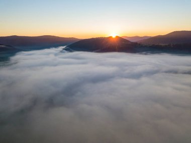 Ukrayna Karpatları 'nda sisin üstünde gün doğumu. Hava aracı görünümü.