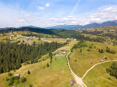 Yazın Ukrayna Karpatları 'nın yeşil dağları. Güneşli bir gün, nadir bulutlar. Hava aracı görünümü.