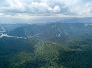 Yazın Ukrayna Karpatları 'nın yeşil dağları. Güneşli bir gün, nadir bulutlar. Hava aracı görünümü.