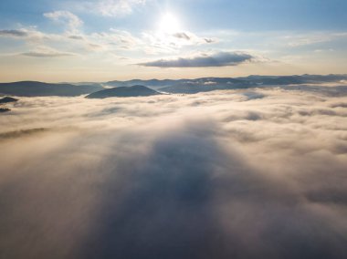 Ukrayna Karpatları 'nda yaz aylarında sislerin üzerinden uçarlar. Ufuktaki dağlar. Yoğun bir sis tabakası daimi bir halıyla dağları kaplar. Hava aracı görünümü.