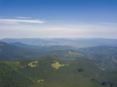 Bulutlu havada Ukrayna Karpatlarının yüksek dağları. Hava aracı görünümü.