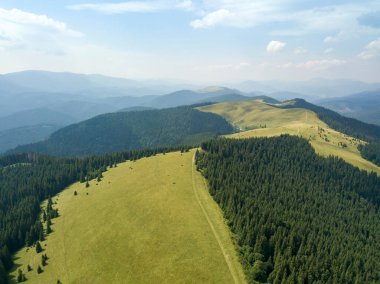 Yazın Ukrayna Karpatları 'nın yeşil dağları. Güneşli bir gün, nadir bulutlar. Hava aracı görünümü.