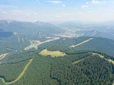 Yazın Ukrayna Karpatları 'nın yeşil dağları. Güneşli bir gün, nadir bulutlar. Hava aracı görünümü.