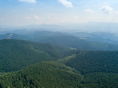 Yazın Ukrayna Karpatları 'nın yeşil dağları. Güneşli bir gün, nadir bulutlar. Hava aracı görünümü.