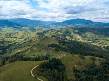 Yazın Ukrayna Karpatları 'nın yeşil dağları. Yamaçlarda kozalaklı ağaçlar. Hava aracı görünümü.