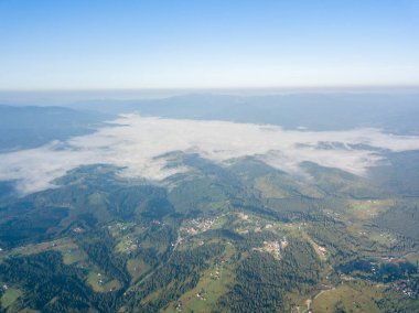 Ukrayna Karpatlarının dağlarında yüksek uçuş. Vadide sis var. Hava aracı görünümü.