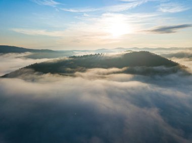 Sisli Karpatlar 'da güneşli bir sabah. Dağları ince bir sis tabakası kaplıyor. Hava aracı görünümü.