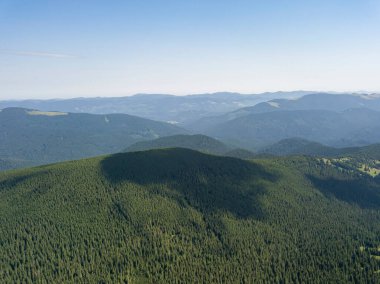 Bulutlu havada Ukrayna Karpatlarının yüksek dağları. Hava aracı görünümü.