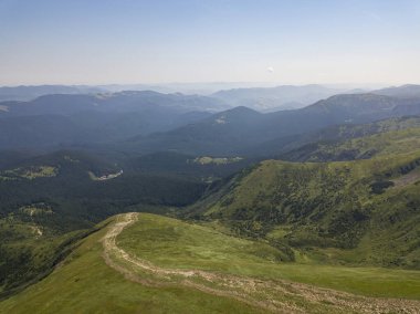 Bulutlu havada Ukrayna Karpatlarının yüksek dağları. Hava aracı görünümü.