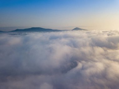 Ukrayna Karpatları 'nda yaz aylarında sislerin üzerinden uçarlar. Ufuktaki dağlar. Hava aracı görünümü.