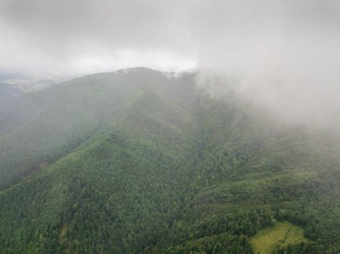 Ukrayna Karpatlarının yeşil dağları bulutların üzerinde dinleniyor. Hava aracı görünümü.