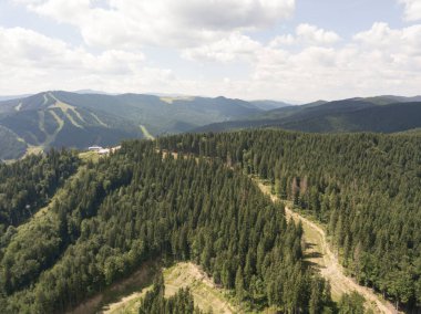 Yazın Ukrayna Karpatları 'nın yeşil dağları. Güneşli bir gün, nadir bulutlar. Hava aracı görünümü.