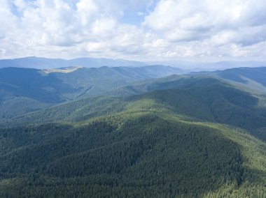 Yazın Ukrayna Karpatları 'nın yeşil dağları. Güneşli bir gün, nadir bulutlar. Hava aracı görünümü.