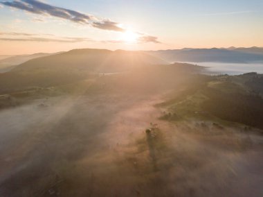 Ukrayna Karpatları 'nda sisin üstünde gün doğumu. Hava aracı görünümü.