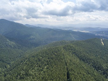 Yazın Ukrayna Karpatları 'nın yeşil dağları. Güneşli bir gün, nadir bulutlar. Hava aracı görünümü.