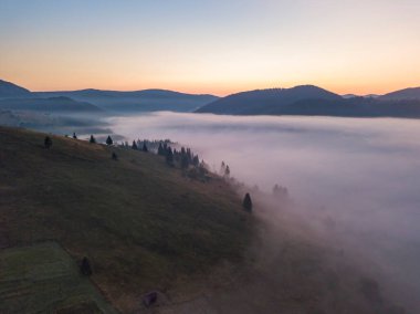 Ukrayna Karpatları 'nda sisin üstünde gün doğumu. Hava aracı görünümü.