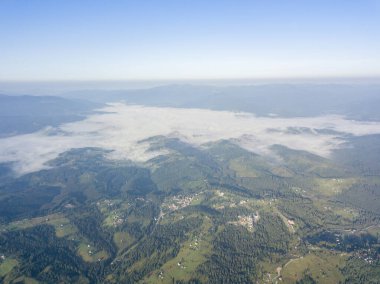 Ukrayna Karpatlarının dağlarında yüksek uçuş. Vadide sis var. Hava aracı görünümü.