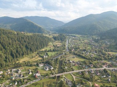 Yazın Ukrayna Karpatları 'nın yeşil dağları. Yamaçlarda kozalaklı ağaçlar. Hava aracı görünümü.