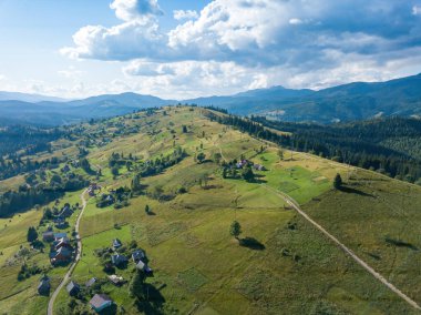 Yazın Ukrayna Karpatları 'nın yeşil dağları. Güneşli bir gün, nadir bulutlar. Hava aracı görünümü.