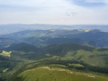 Bulutlu havada Ukrayna Karpatlarının yüksek dağları. Hava aracı görünümü.