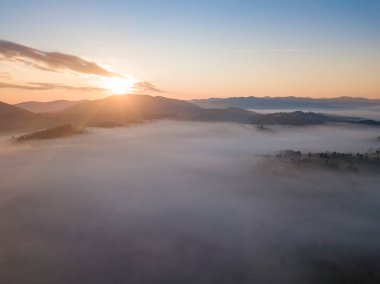Ukrayna Karpatları 'nda sisin üstünde gün doğumu. Hava aracı görünümü.