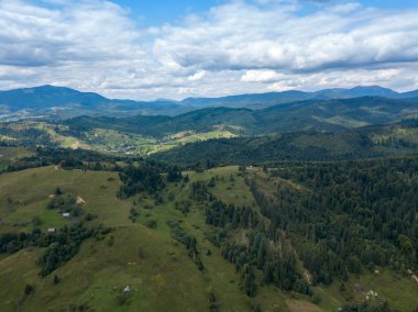 Yazın Ukrayna Karpatları 'nın yeşil dağları. Yamaçlarda kozalaklı ağaçlar. Hava aracı görünümü.