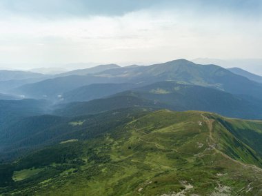 Bulutlu havada Ukrayna Karpatlarının yüksek dağları. Hava aracı görünümü.
