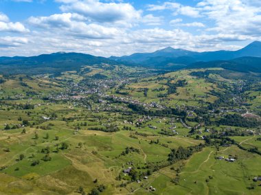Yazın Ukrayna Karpatları 'nın yeşil dağları. Yamaçlarda kozalaklı ağaçlar. Hava aracı görünümü.