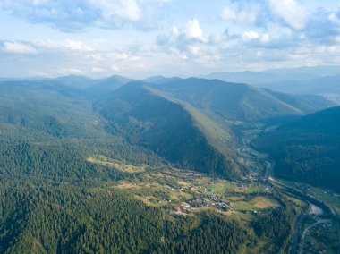 Yazın Ukrayna Karpat Dağları 'nın yeşil yamaçlarında. Bulutlu bir gün, alçak bulutlar. Hava aracı görünümü.