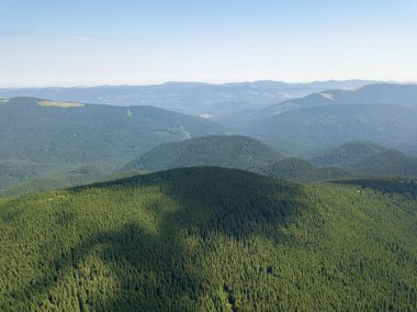 Bulutlu havada Ukrayna Karpatlarının yüksek dağları. Hava aracı görünümü.