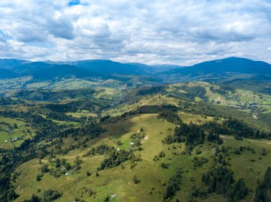 Yazın Ukrayna Karpatları 'nın yeşil dağları. Yamaçlarda kozalaklı ağaçlar. Hava aracı görünümü.