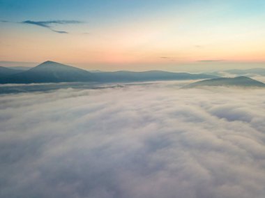 Ukrayna Karpatları 'nda sislerin üzerindeki şafak ışınları. Hava aracı görünümü.