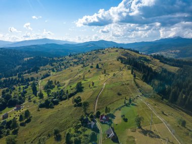 Yazın Ukrayna Karpatları 'nın yeşil dağları. Güneşli bir gün, nadir bulutlar. Hava aracı görünümü.