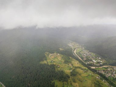 Ukrayna Karpatlarının yeşil dağları bulutların üzerinde dinleniyor. Hava aracı görünümü.