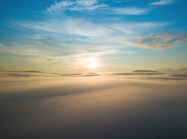 Ukrayna Karpatları 'nda sislerin üzerindeki şafak ışınları. Hava aracı görünümü.