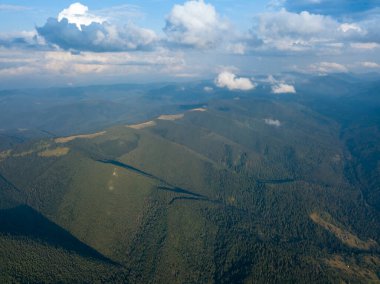 Yazın Ukrayna Karpat Dağları 'nın yeşil yamaçlarında. Bulutlu bir gün, alçak bulutlar. Hava aracı görünümü.