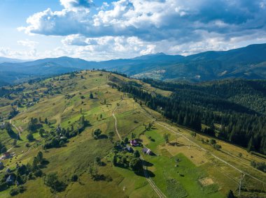 Yazın Ukrayna Karpatları 'nın yeşil dağları. Güneşli bir gün, nadir bulutlar. Hava aracı görünümü.